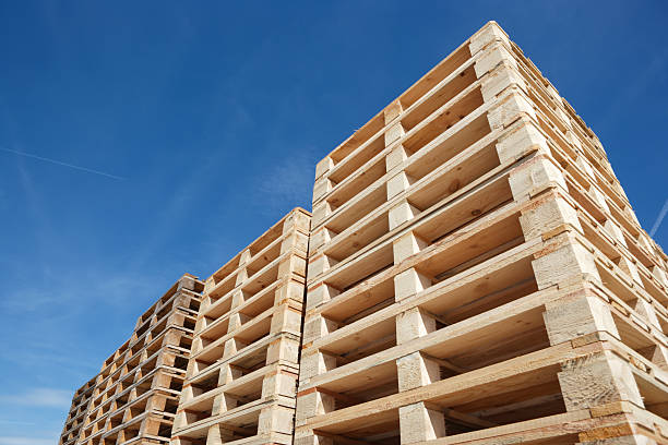 stack of wooden pallets against clear blue sky, low angle view